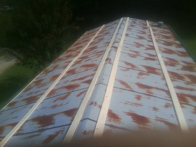 Rusted metal roof panels with new wood purlins before replacement — Storm Damage Roof Repair in Chinook by Roofing Brothers