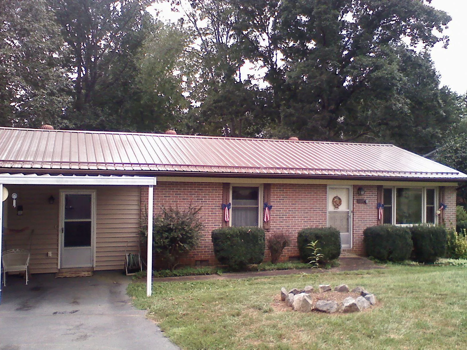 Bronze metal roof and carport on a brick ranch home — Roof Repair work by our crew in Chinook